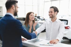 A couple signing a Chevrolet financing deal at a dealership