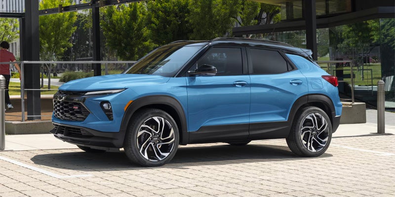 Blue Chevrolet Trailblazer SUV parked outside a modern building.